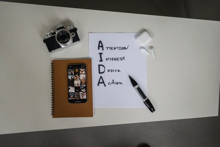 Top view of AIDA marketing elements with notebook, smartphone, camera, and earbu