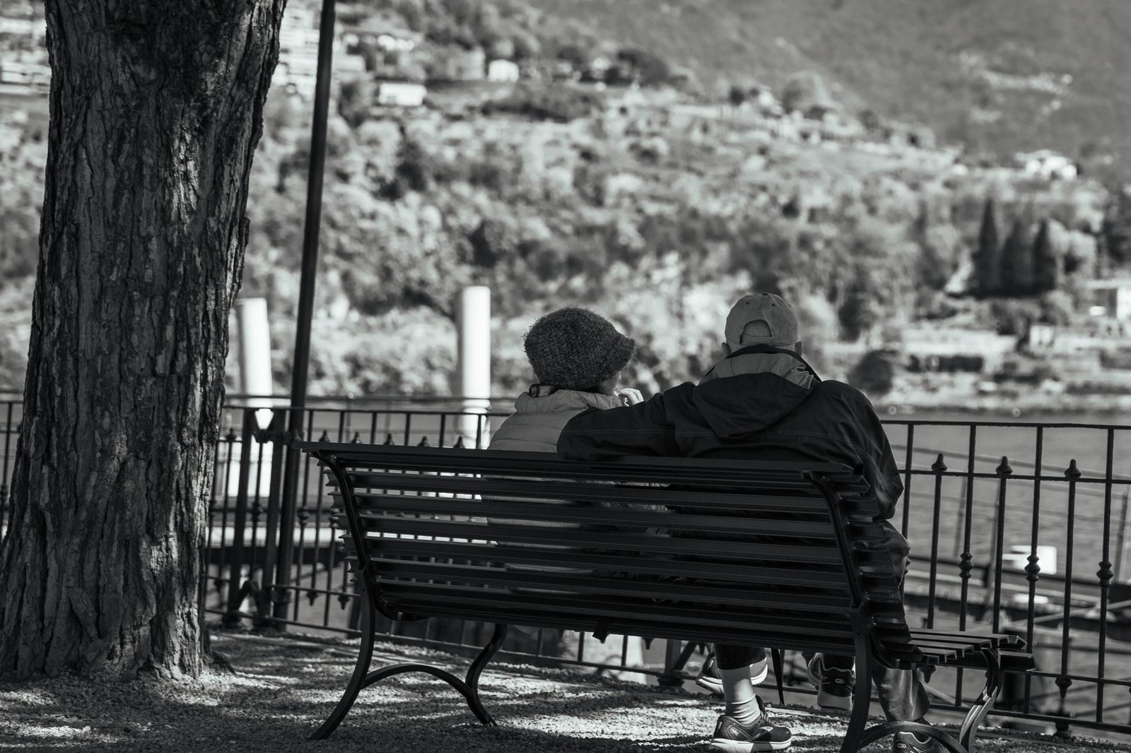 Planejamento previdenciario: como escolher a melhor data para se aposentar 1 Serene moment of an elderly couple on a bench overlooking Lake Como.