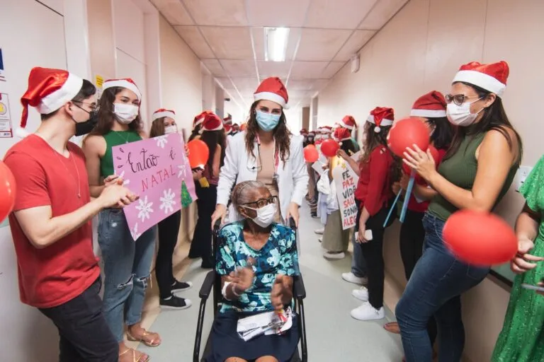 A joyful Christmas celebration in a hospital corridor with staff and visitors in