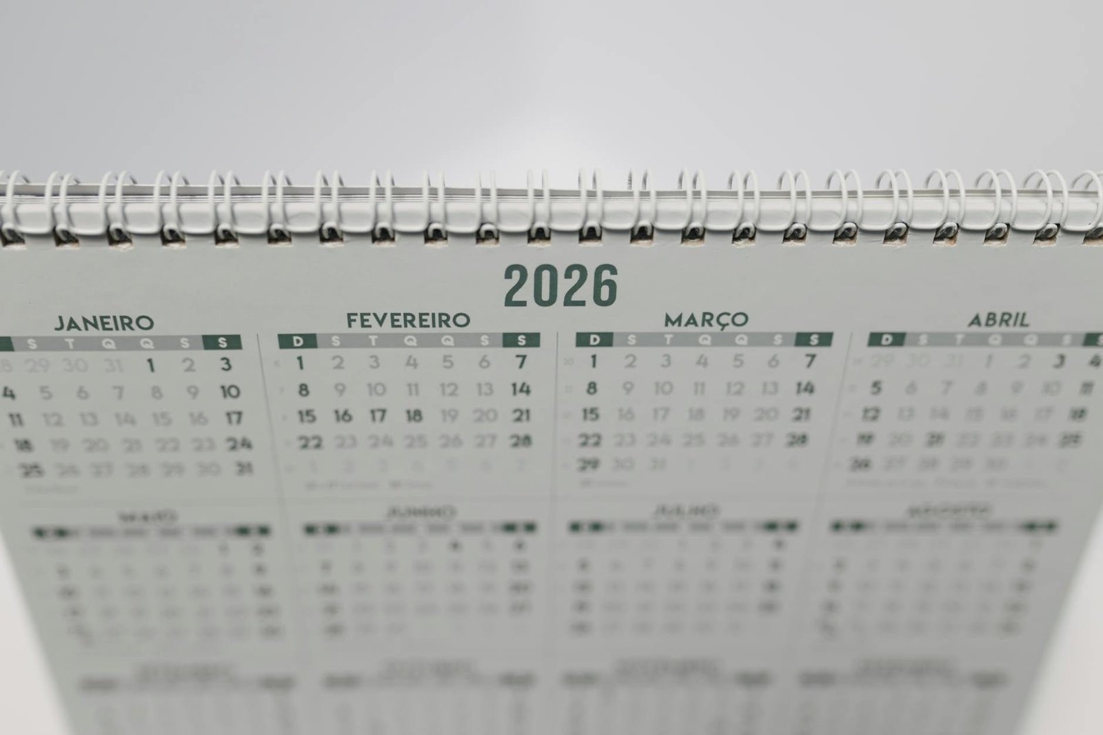Close-up of a 2026 spiral-bound desk calendar with months in Portuguese.