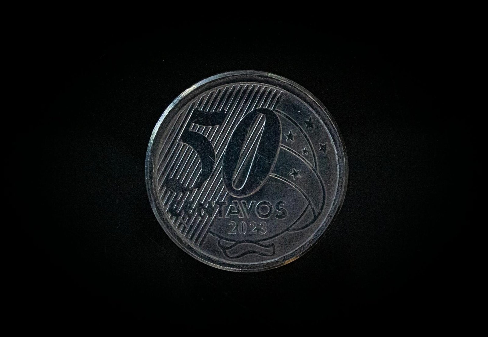 Detailed macro shot of a 50 Centavos coin from 2023 on a dark background.