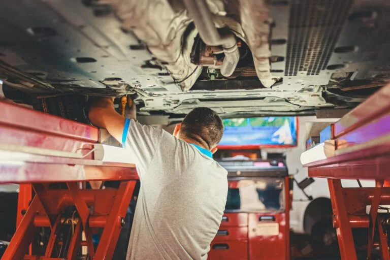 Mecânico realizando reparo em veículo automotor durante procedimento de recall