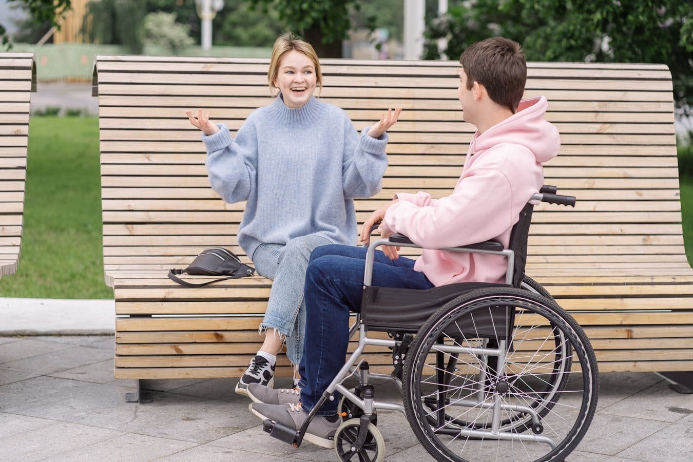 Cálculo da Renda Familiar per Capita no BPC 1 Smiling couple enjoying conversation on a wooden bench outdoors. Inclusive and friendly atmosphere.