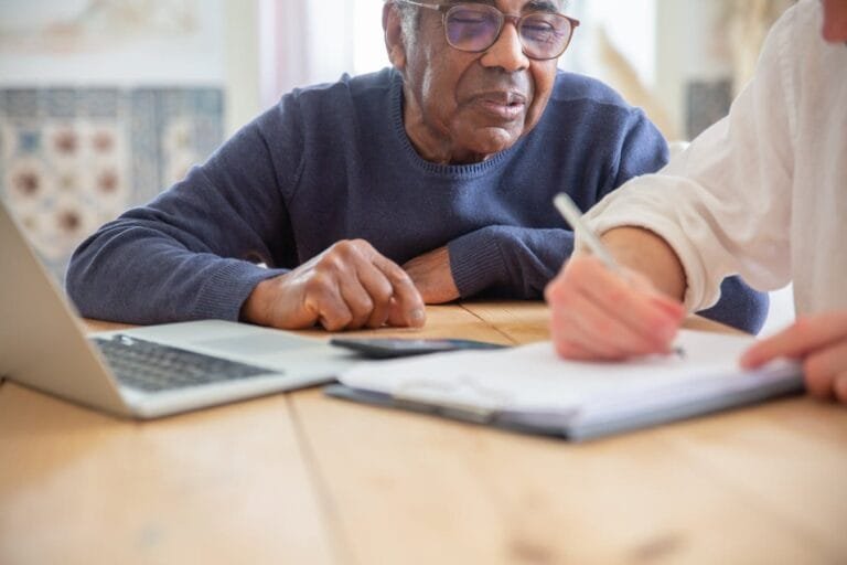 Como o INSS transformou o Judiciário no balcão da Previdência 2 Senior African American man receiving assistance with paperwork at home.