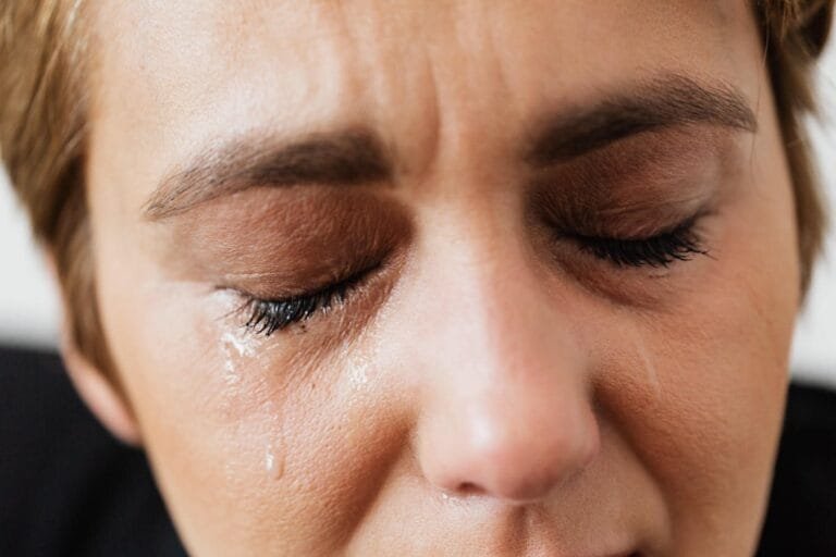 Dano Moral: Critérios para Caracterização e Valor da Indenização 3 Closeup of crop unrecognizable middle aged woman suffering from depression and crying with closed eyes