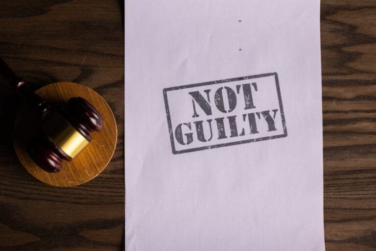 A courtroom document labeled Not Guilty beside a gavel symbolizes justice.