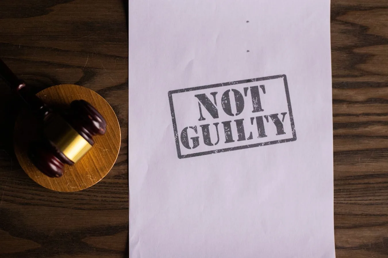 A courtroom document labeled Not Guilty beside a gavel symbolizes justice.