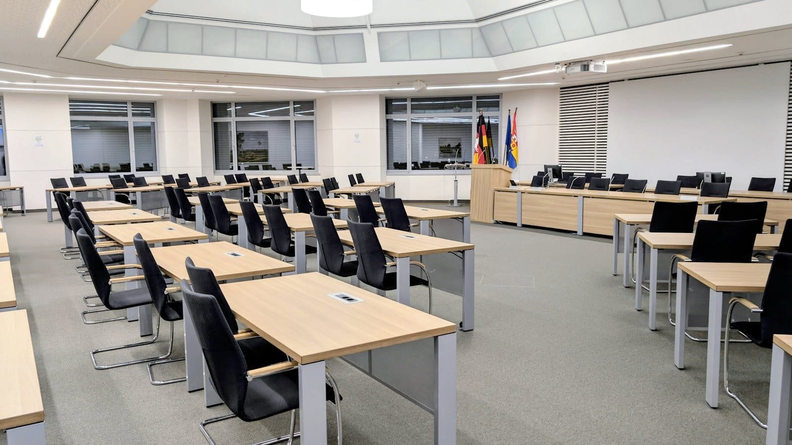 Fachin derruba liminar que suspendia concessão de alvarás na cidade de São Paulo 1 Spacious and modern meeting room in Niedersachsen, Germany, with desks and flags.