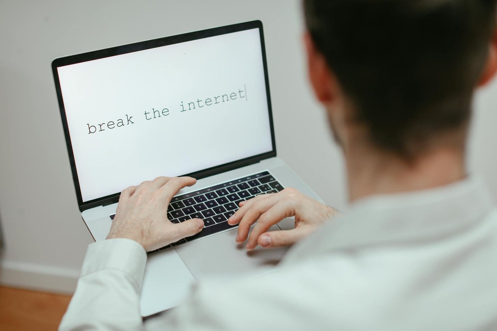 A person typing on a laptop showing the provocative message break the internet