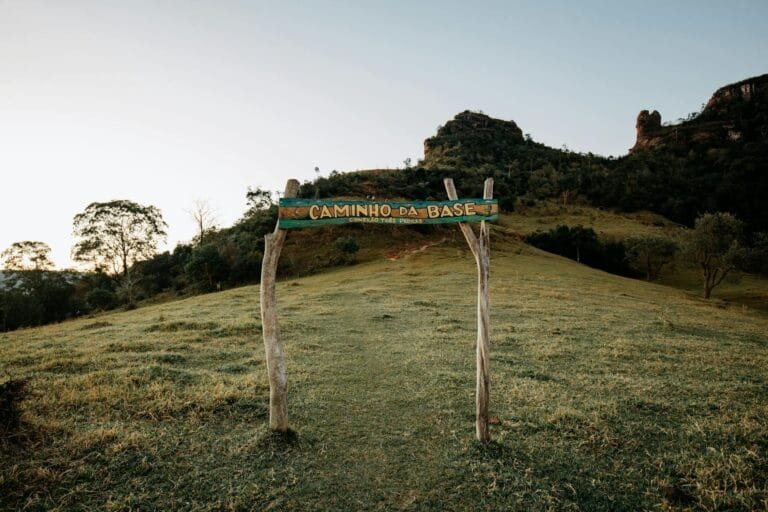 Trail entrance at Caminho da Base amidst scenic Brazilian landscape, lush greene