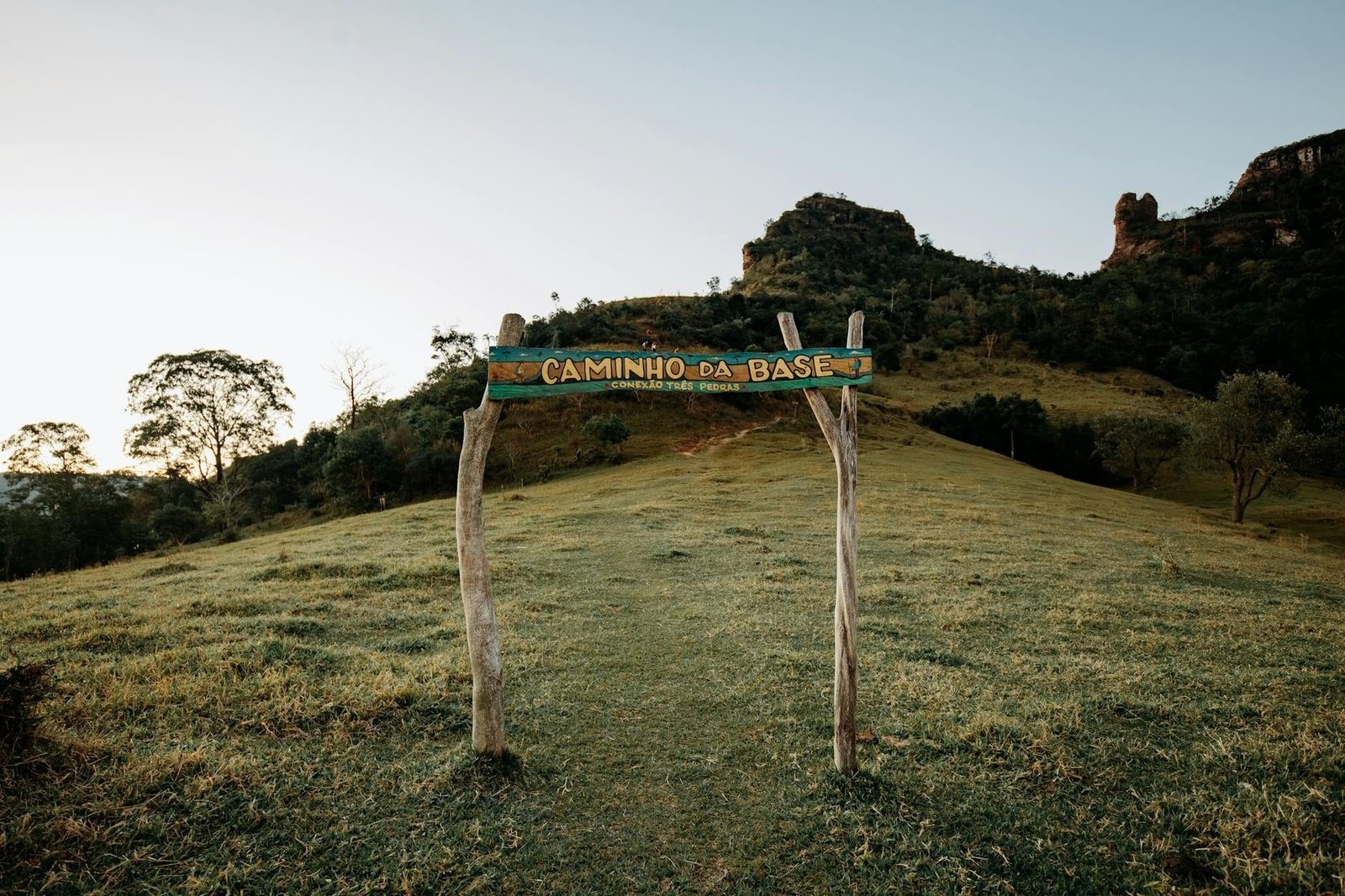 Trail entrance at Caminho da Base amidst scenic Brazilian landscape, lush greene