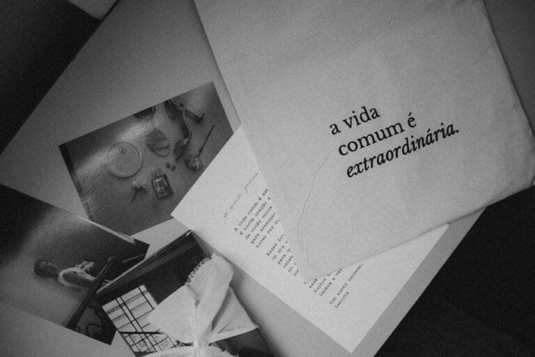 Monochrome still life featuring Portuguese text a vida comum é extraordinária 