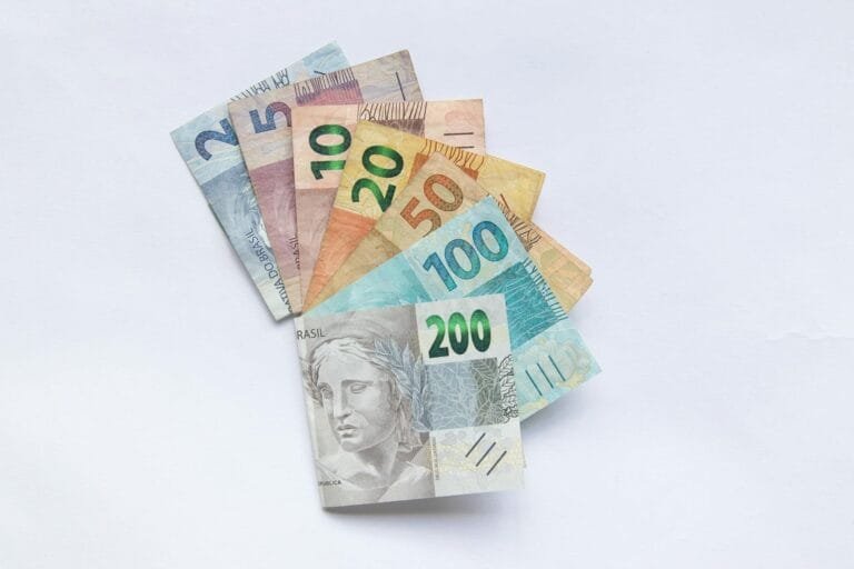A fan arrangement of colorful Brazilian Real banknotes on a white background sho