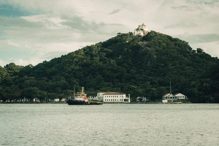 Lei Maria da Penha: Medidas Protetivas de Urgência 3 A tranquil scene featuring a boat and the historic Nossa Senhora da Penha Conven