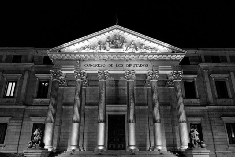 Black and white photo of the Congress of Deputies facade in Madrid by night.