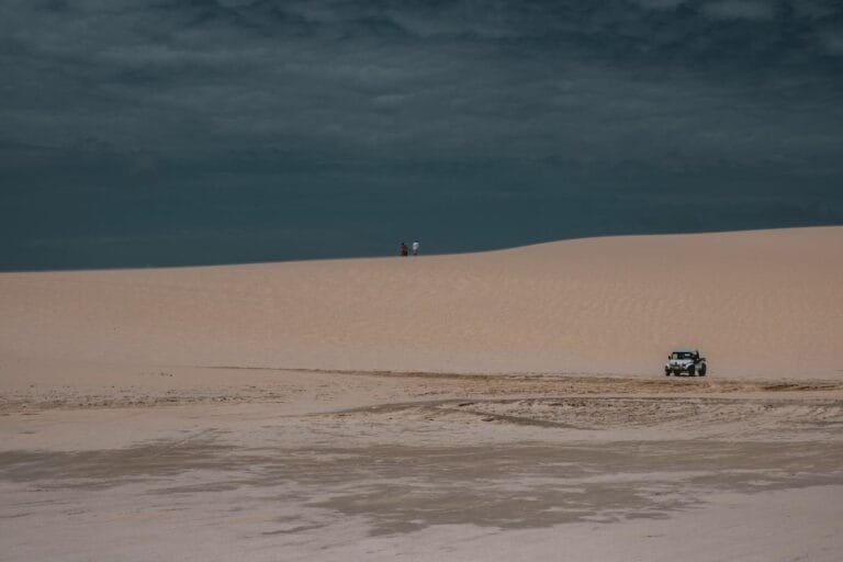 Pensao por Morte para Filhos Maiores: Casos Especiais e Continuidade do Beneficio 4 Jeep navigating the sandy dunes of Jericoacoara desert under a cloudy sky.