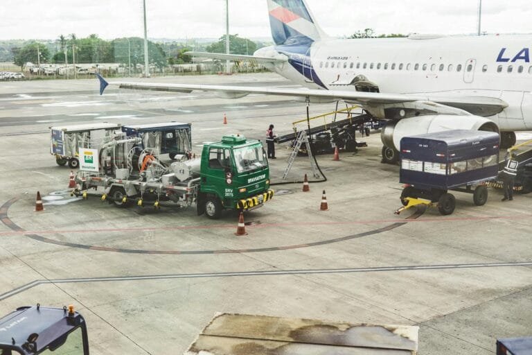 Ground support services in action at an airport terminal with visible aircraft a