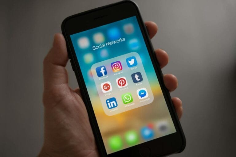 Ofensas em Redes Sociais: Quando Cabe Indenizacao por Dano Moral 3 A smartphone displaying various social media icons held in a hand, showcasing mo