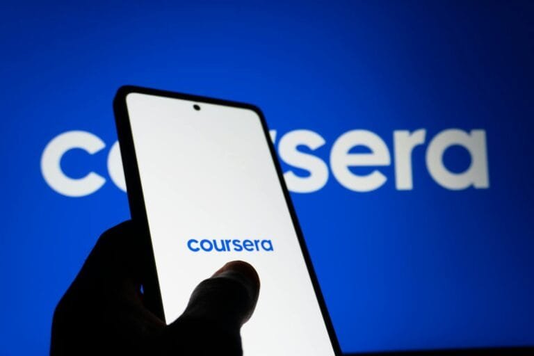 A smartphone screen showing the Coursera logo with a background featuring the sa