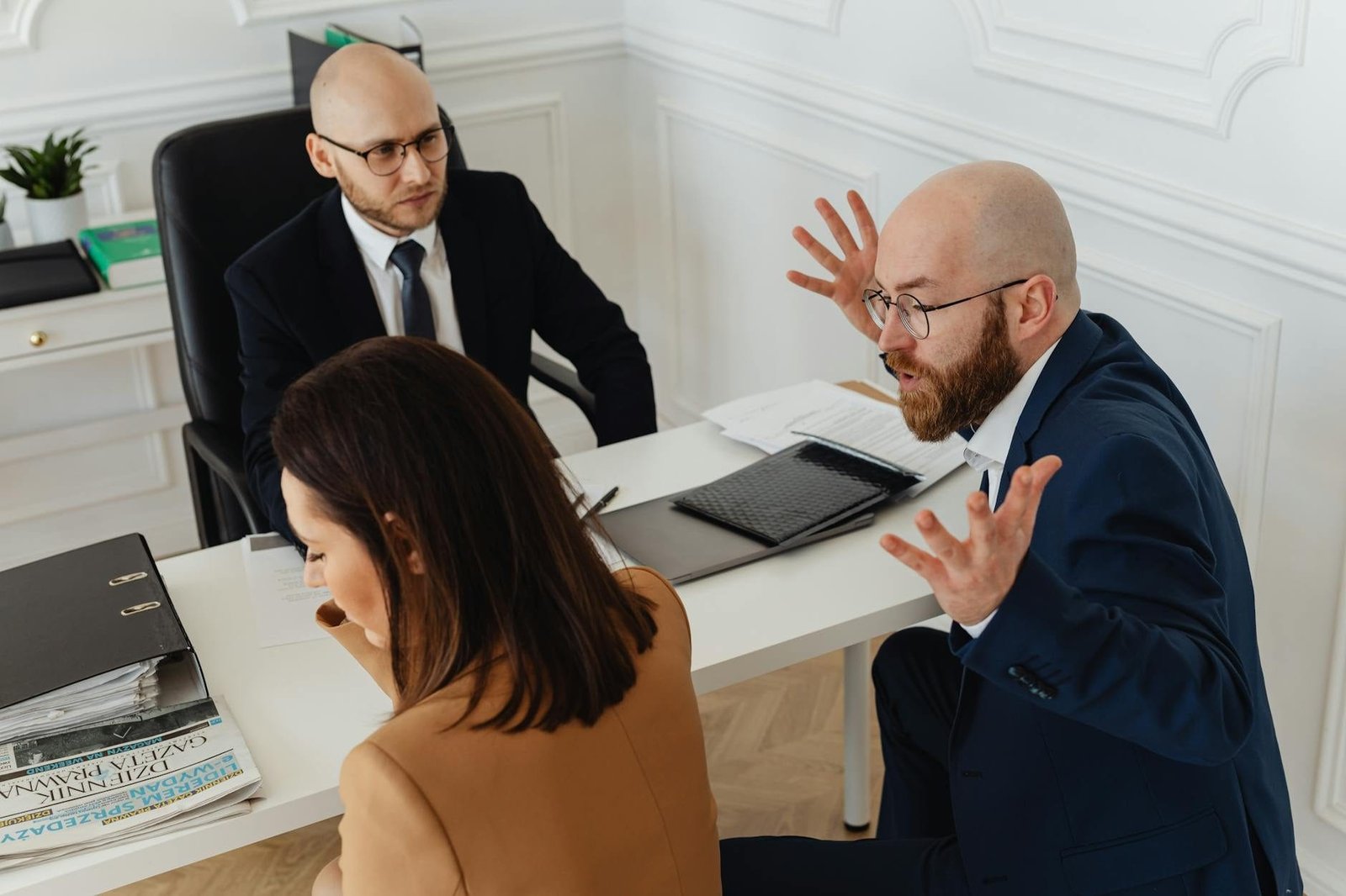 Clausulas Abusivas em Contratos Civis: Como Identificar e Anular 1 Three colleagues in a heated discussion during an office meeting.