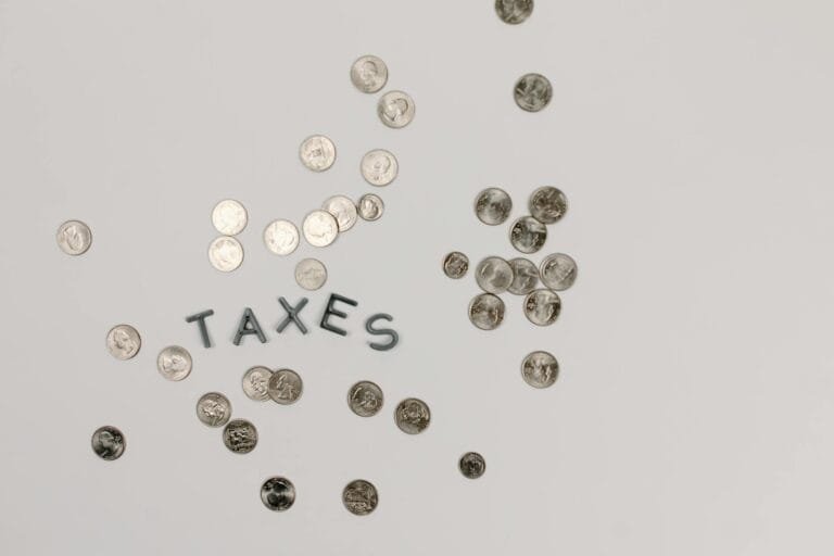 A visually striking flatlay of coins with Taxes text on a white surface, ideal
