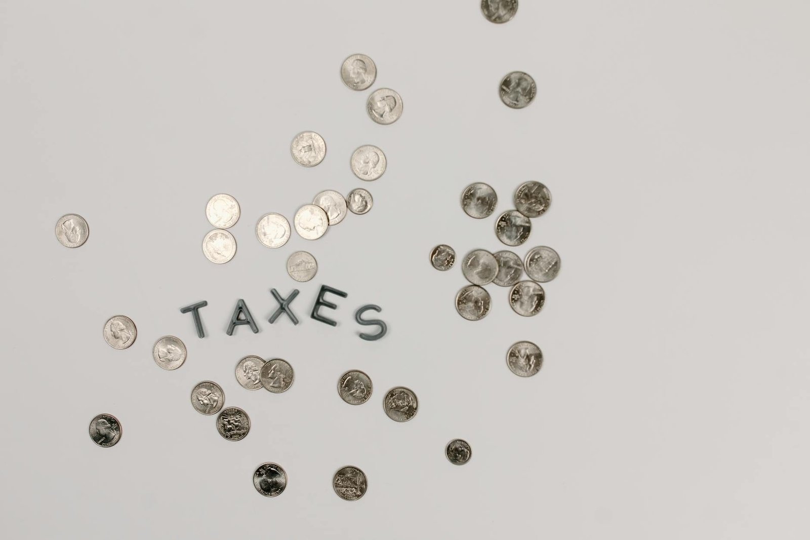 A visually striking flatlay of coins with Taxes text on a white surface, ideal