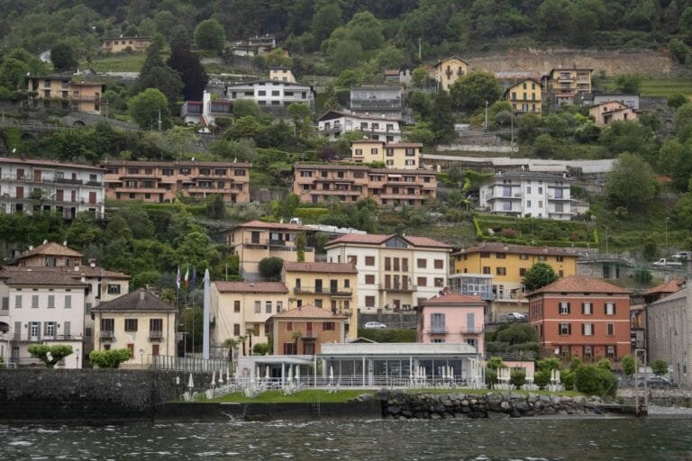 Charming hillside houses by Lake Como with lush greenery in Italy, perfect for t