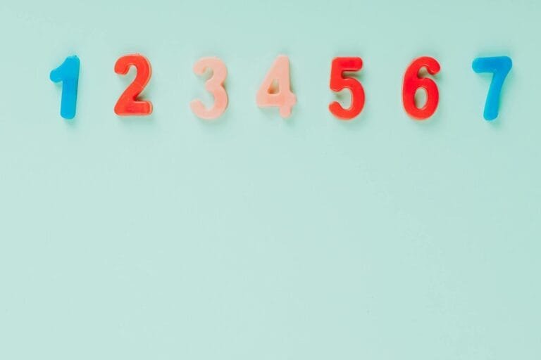 Idade Mínima Progressiva: O Cálculo Ano a Ano 7 Bright plastic numbers on a blue background with ample copy space, ideal for edu