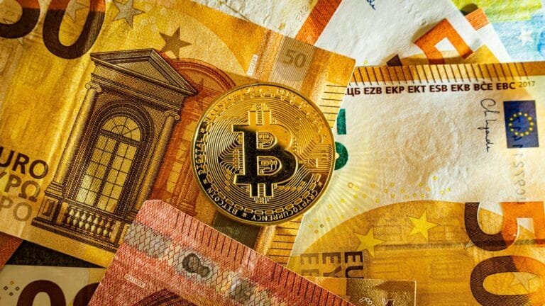 Golden Bitcoin coin placed on euro banknotes symbolizing digital currency and mo