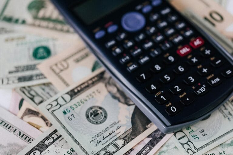 From above of electronic calculator placed over American cash paper money for bu