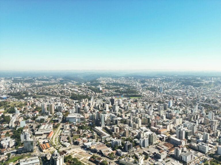 Stunning aerial view of Caxias do Suls urban cityscape under a clear blue sky.