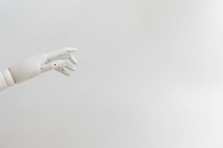 Minimalist image of a robotic hand reaching out on a white background.