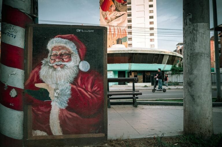 Street art of Santa Claus on a colorful mural in Trujillo, Peru, with urban back