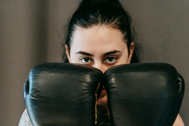 Concentrated young female athlete with long dark hair covering face with hands i