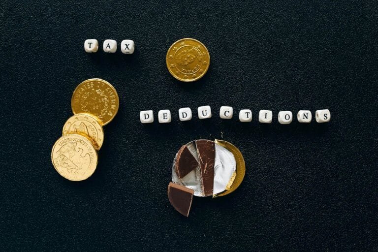 Creative concept of tax deductions using chocolate coins and letter tiles on a b