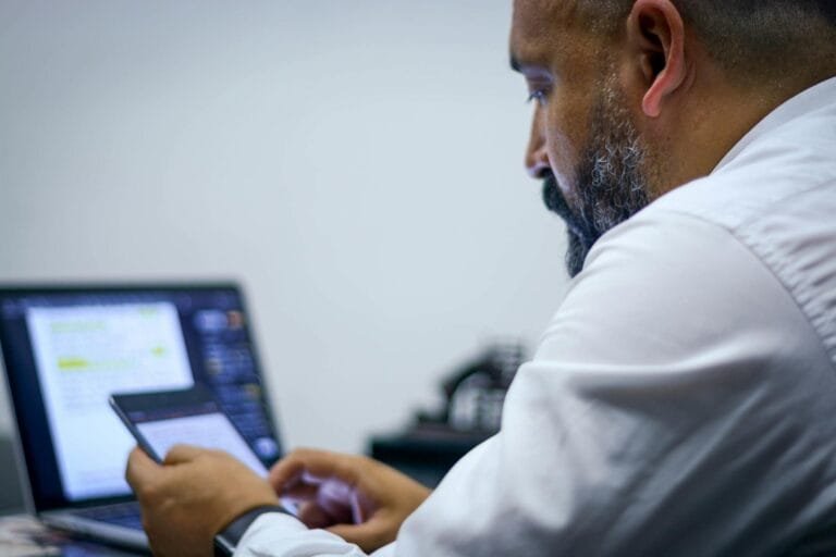 Businessman working with laptop and smartphone, focused and productive.