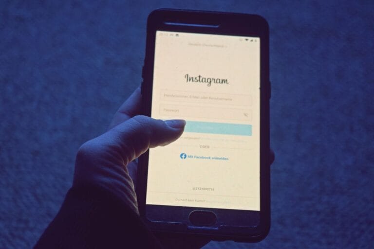 Mão segurando smartphone com tela de login, em referência aos serviços do Meu INSS