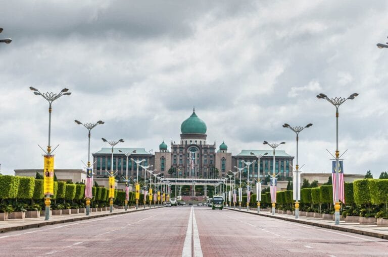 View of the Perdana Putra building, a landmark of Malaysian architecture, from a street perspective.