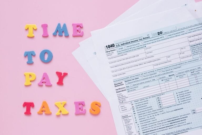 1040 tax forms with colorful Time to Pay Taxes letters.