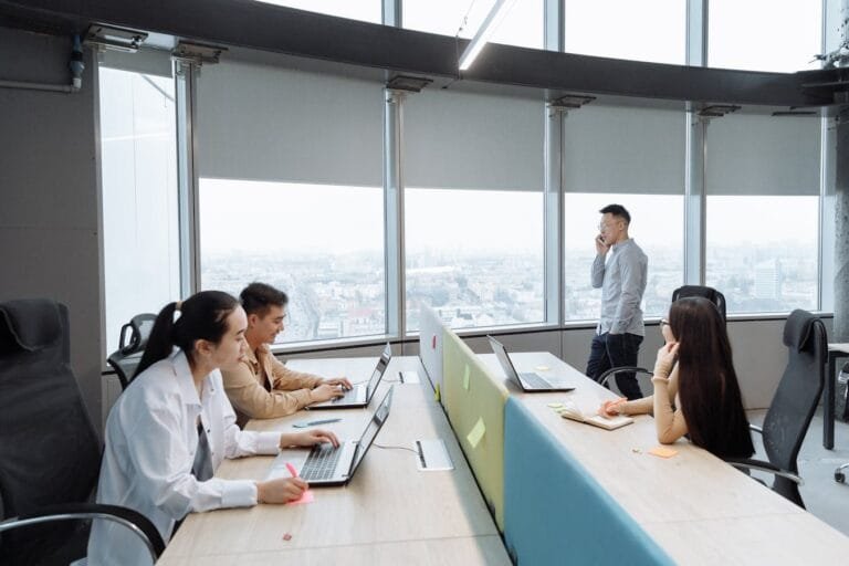 Lei do Estágio: Direitos do Estagiário e Obrigações da Empresa 1 Business team working in a modern office setting with city view.