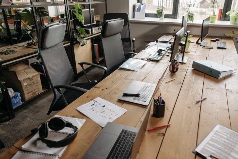 Licença e Afastamento do Servidor: Hipóteses e Garantias 7 Spacious co-working office with wooden desks, laptops, and modern chairs.