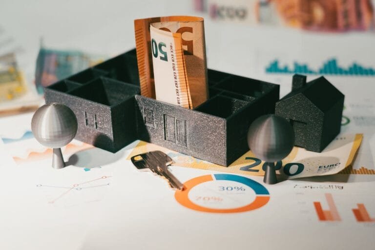 Euro notes with house model and financial charts symbolize real estate investment and economic growth.