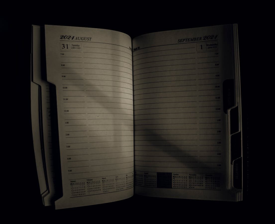 An open planner showing the transition from August to September 2021, symbolizing time management.