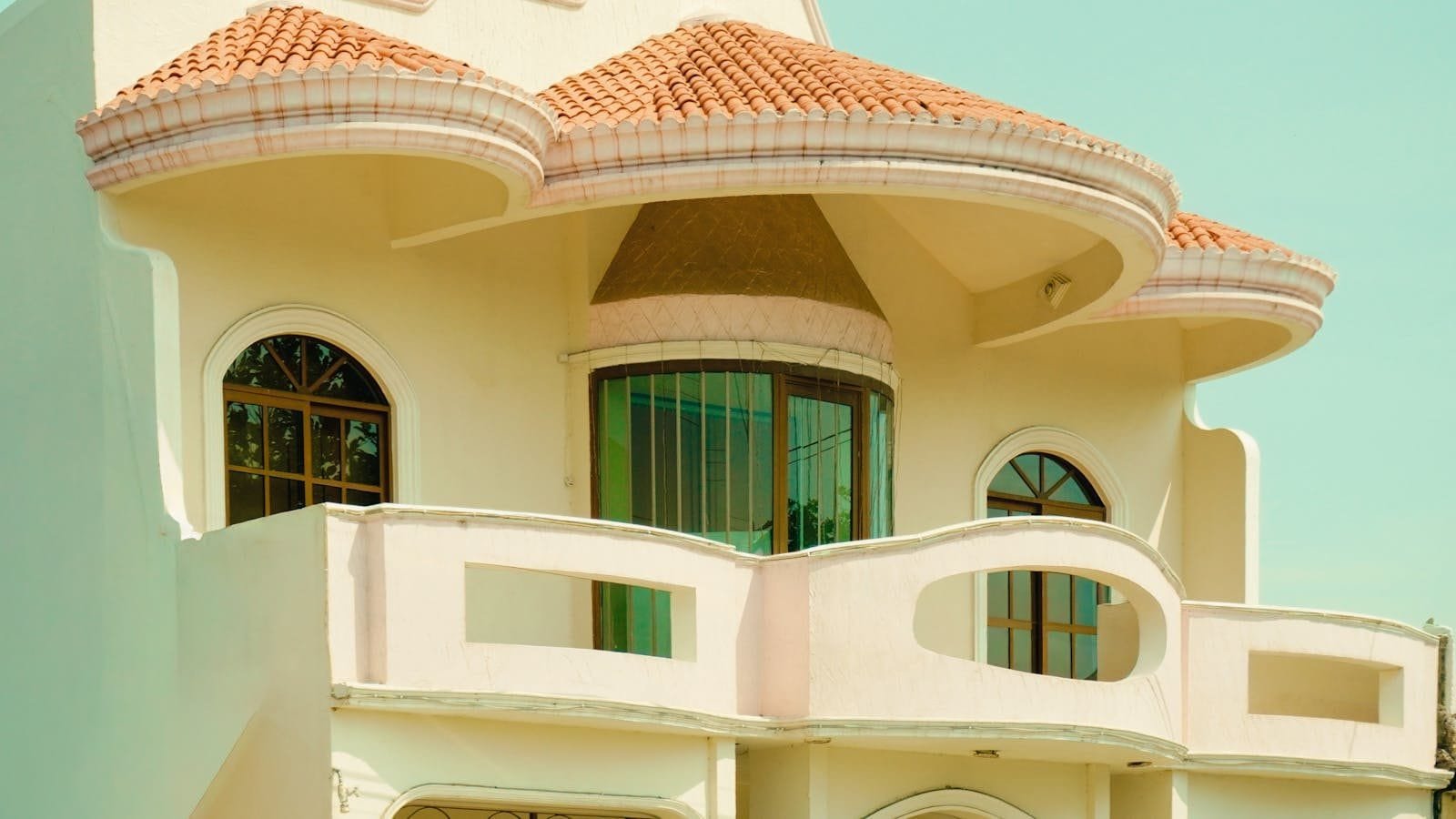 Regularização de Imóvel: Documentação e Averbação 1 Close-up of a Mediterranean-style villa with unique architectural design and terracotta roof.