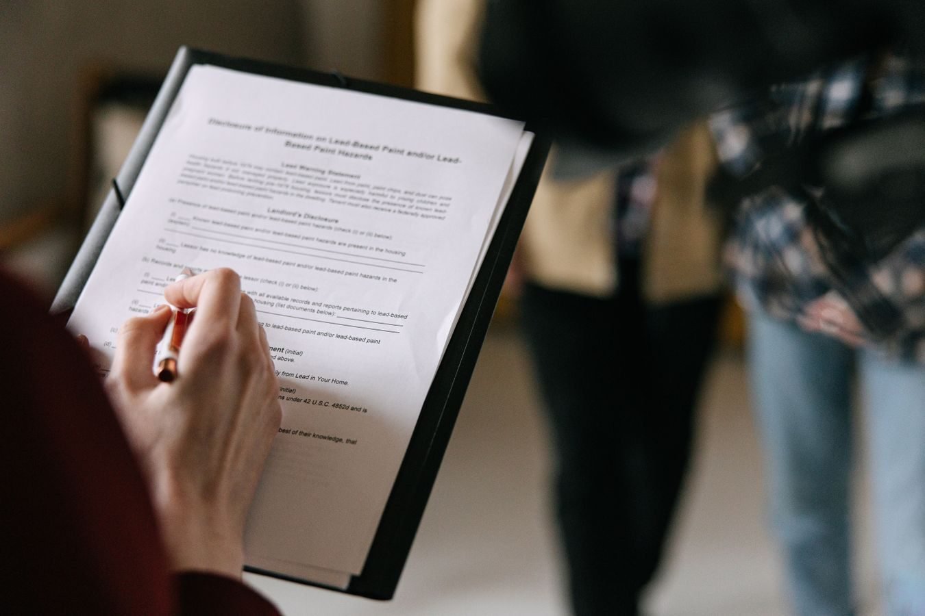 Acao renovatoria: como o comerciante garante a renovacao do ponto comercial 1 A couple examines real estate documents indoors with focus on writing and discussion.