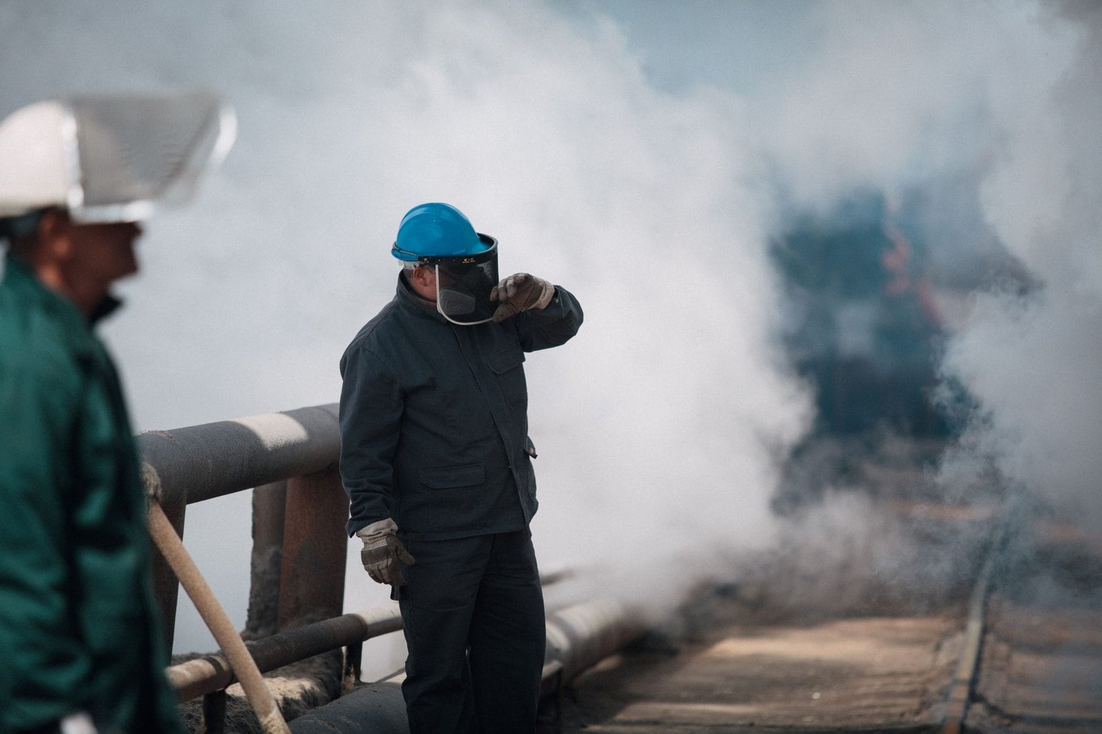 Aposentadoria especial: como o segurado deve comprovar exposição a agentes nocivos e converter tempo especial em 2026 1 Industrial workers wearing protective gear surrounded by heavy smoke, ensuring safety in harsh environments.