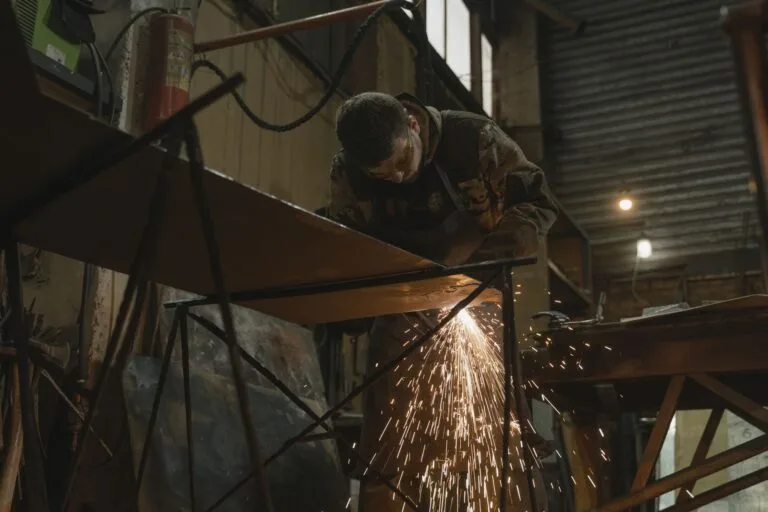 Trabalhador em atividade insalubre cortando metal, tema da aposentadoria especial