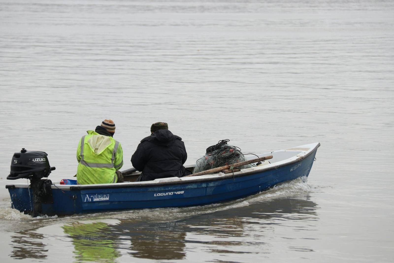 Pescadores artesanais em barco com redes de pesca, atividade com direito à aposentadoria do pescador artesanal