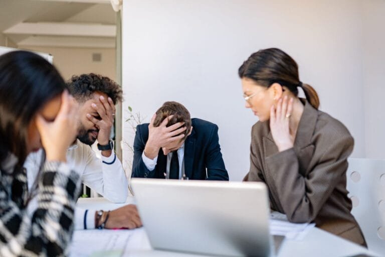 Assédio Moral Contra Servidor Público: Responsabilidade do Estado 7 A group of stressed business professionals in an office setting, overwhelmed by work.