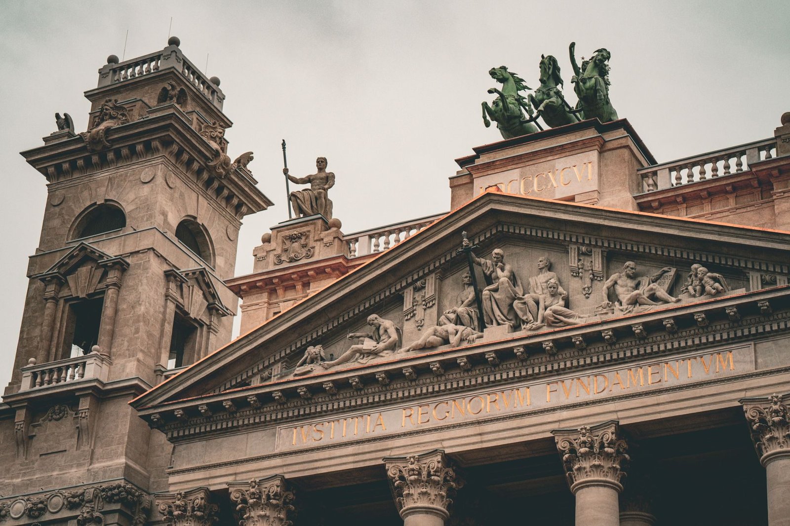 Architectural detail of a historic building in Budapest, featuring sculptures and engraved